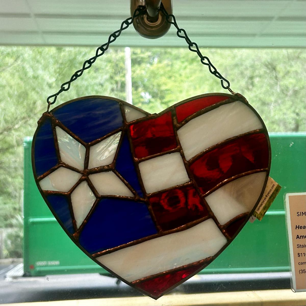 Heart-shaped glass artwork, with red white and blue colors. 