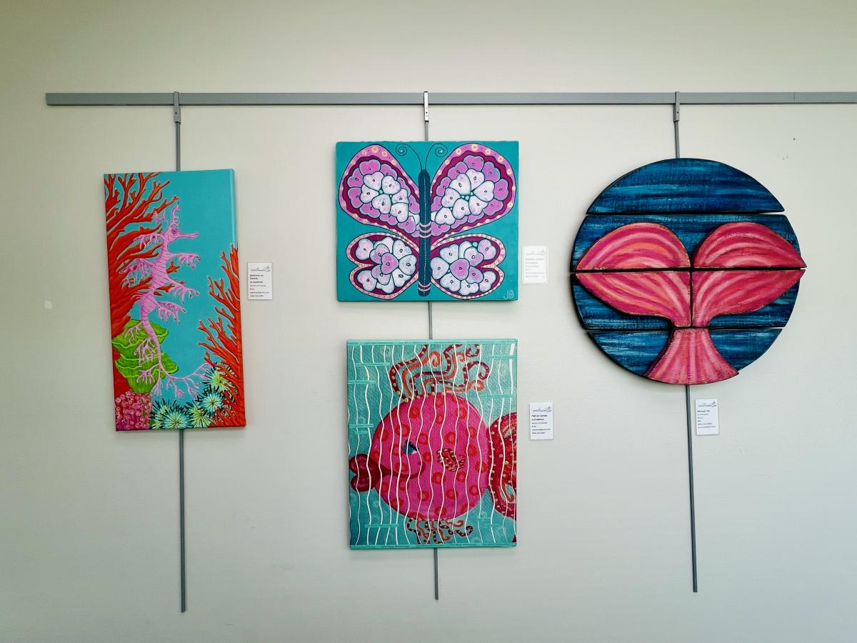 Four pieces of colorful artwork, featuring fish, coral reefs, and butterflies.