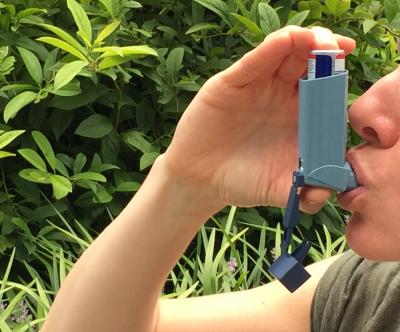 NIAID image of woman using an asthma inhaler